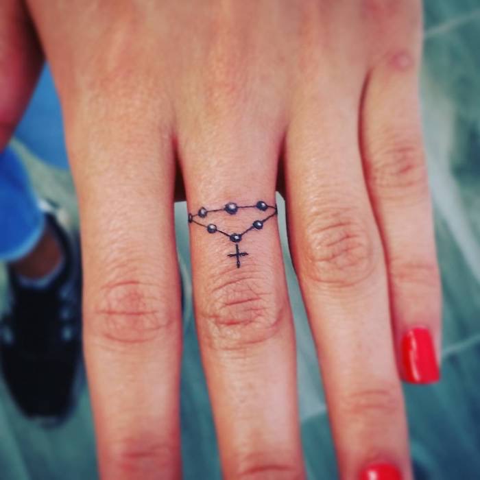 tatuaggio piccolo con croce dito donna